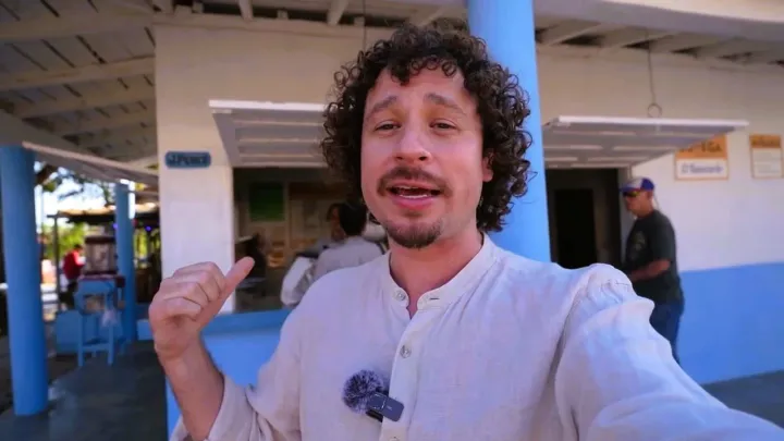 Hombre de pie frente a un edificio azul