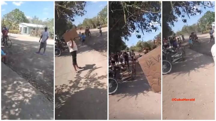 Personas con carteles protestan en una calle rural.