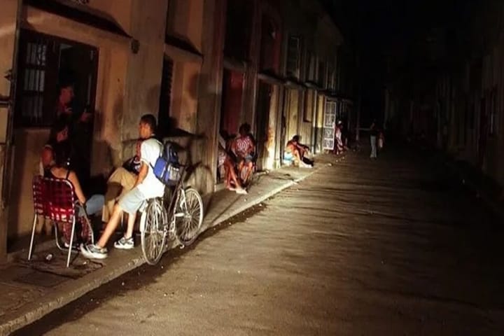 Personas conversando en la calle durante la noche.