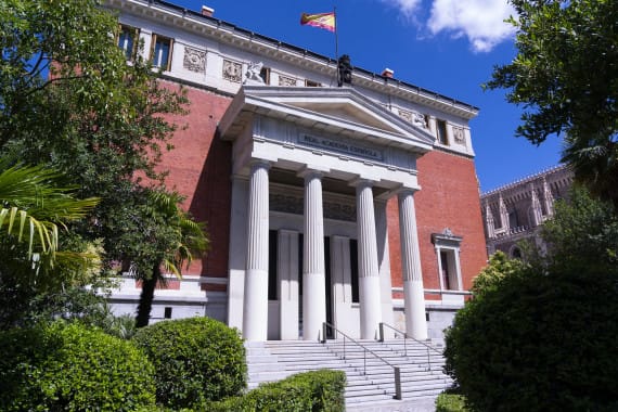 Fachada del Museo del Prado con bandera de España